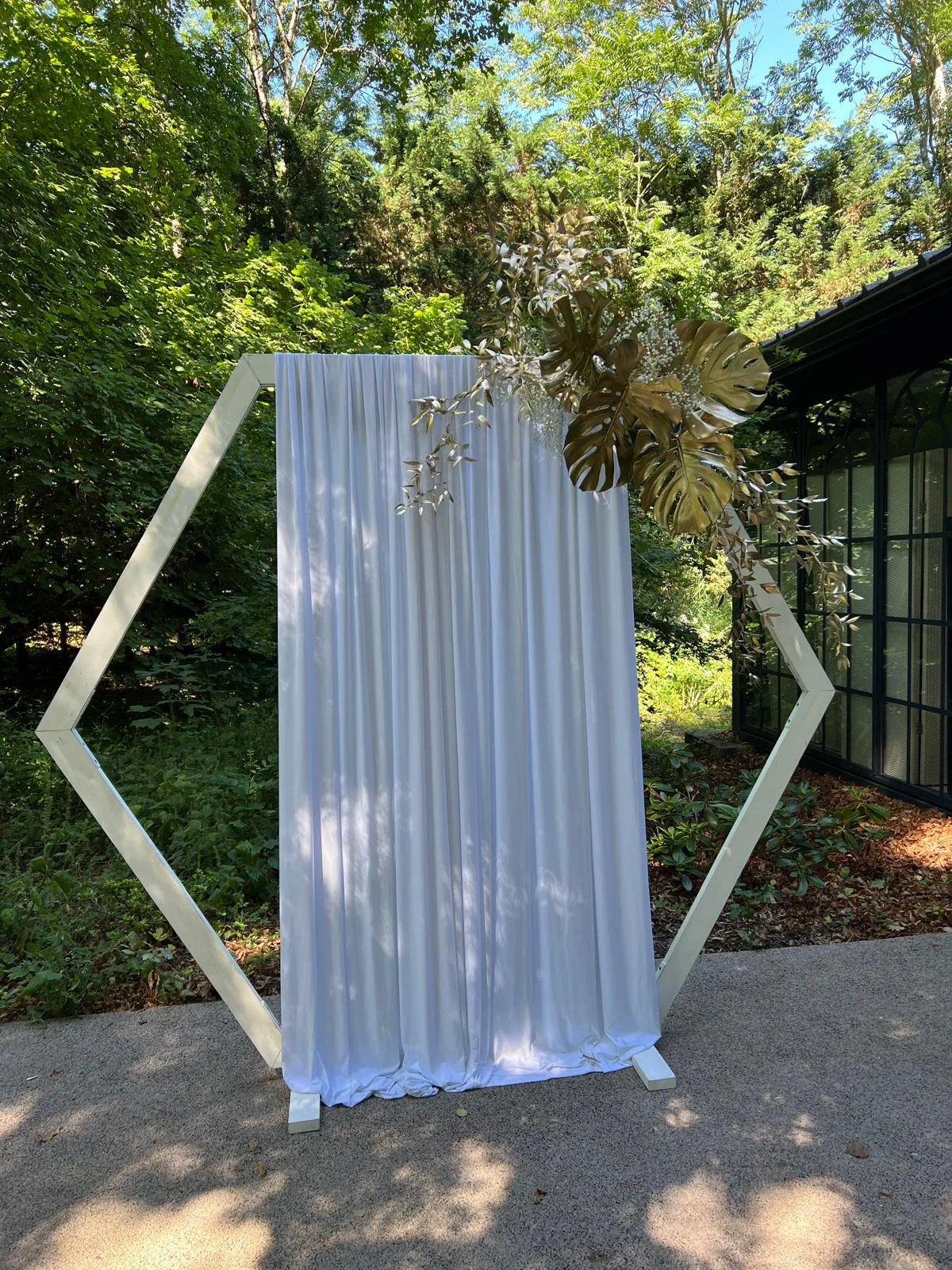 Arche hexagonale blanche et voilage dans un jardin – Armony's Déco