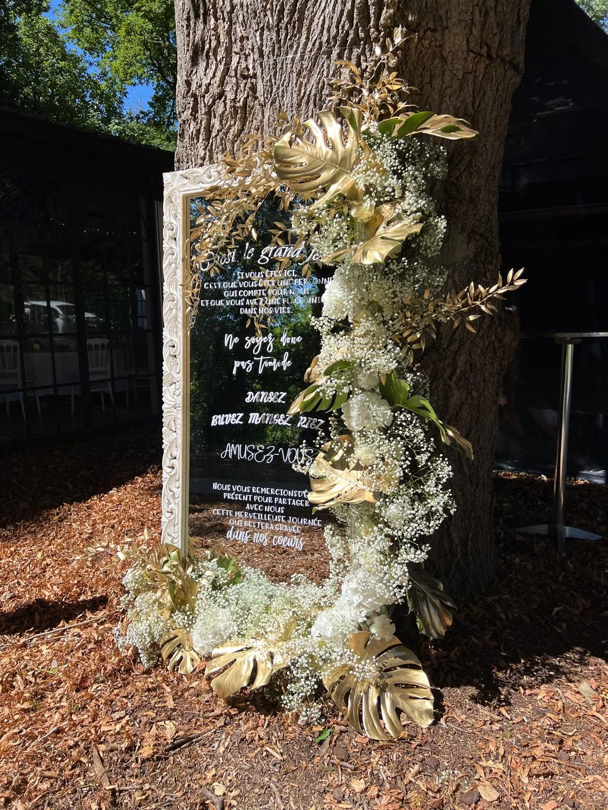 Miroir de bienvenue fleuri de feuillage doré, adossé à un arbre – Armony's Déco