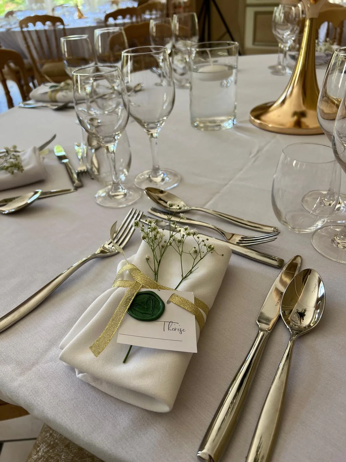 Table dressée, serviettes au sceau de cire vert et ruban doré – Armony's Déco