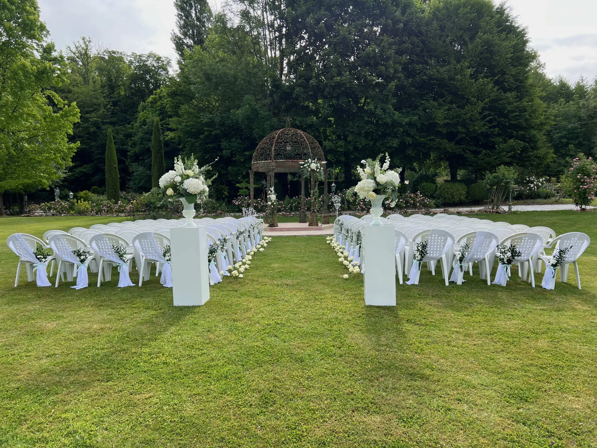 Cérémonie laïque en extérieur avec chaises blanches et décoration florale