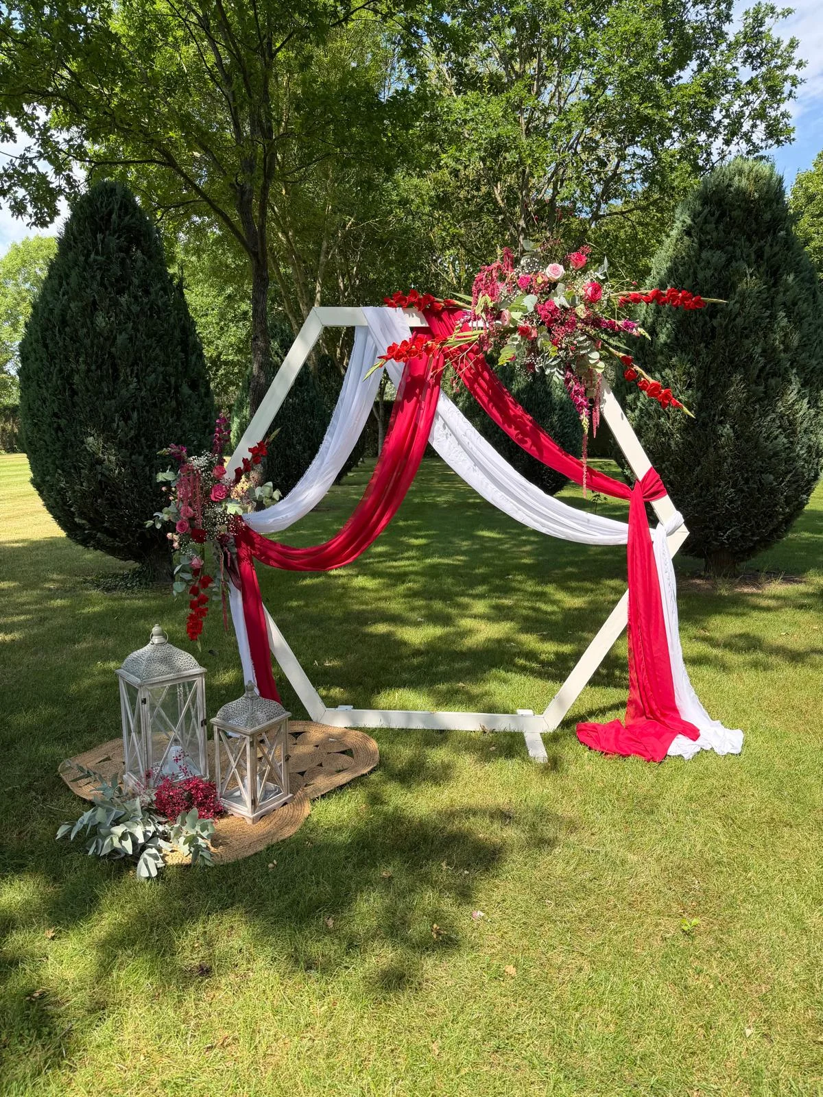 Arche hexagonale aux voilages blanc et rouge pour une cérémonie laïque en extérieur – Armony's Déco