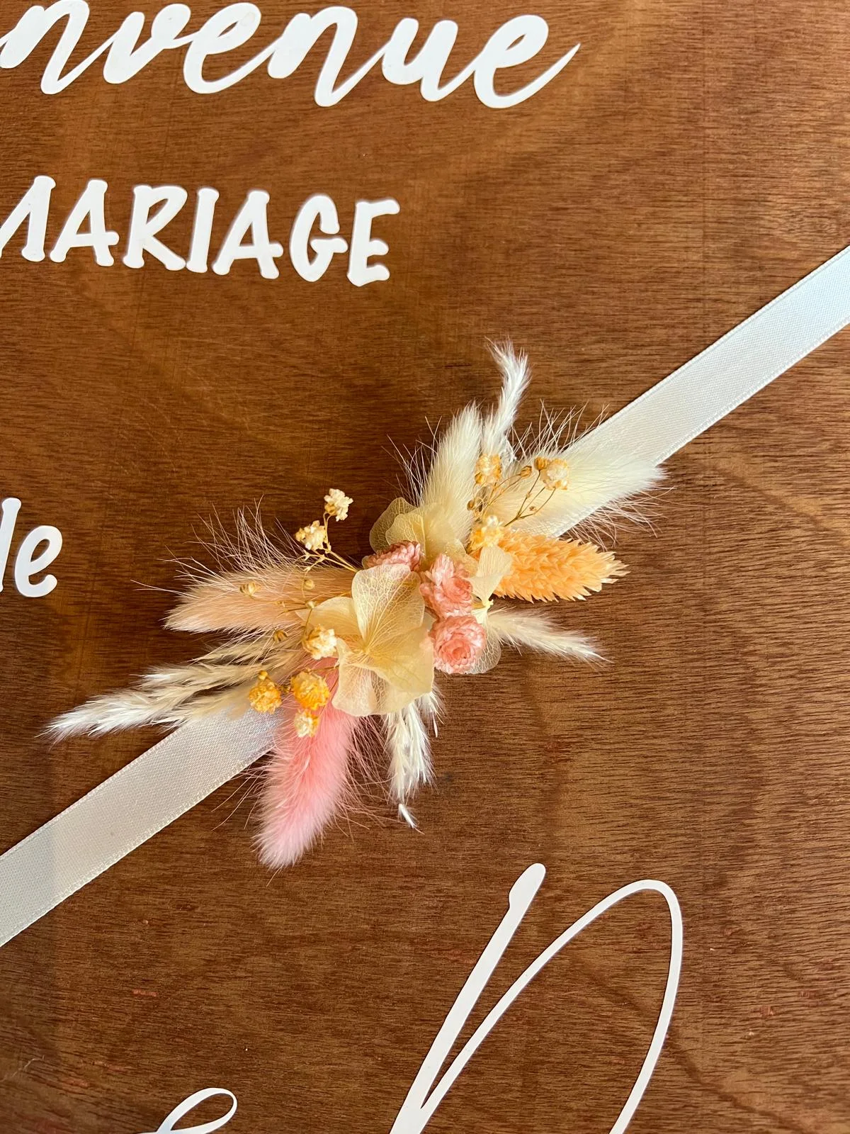 Bracelet de fleurs séchées sur ruban blanc, posé sur le panneau de bienvenue – Armony's Déco
