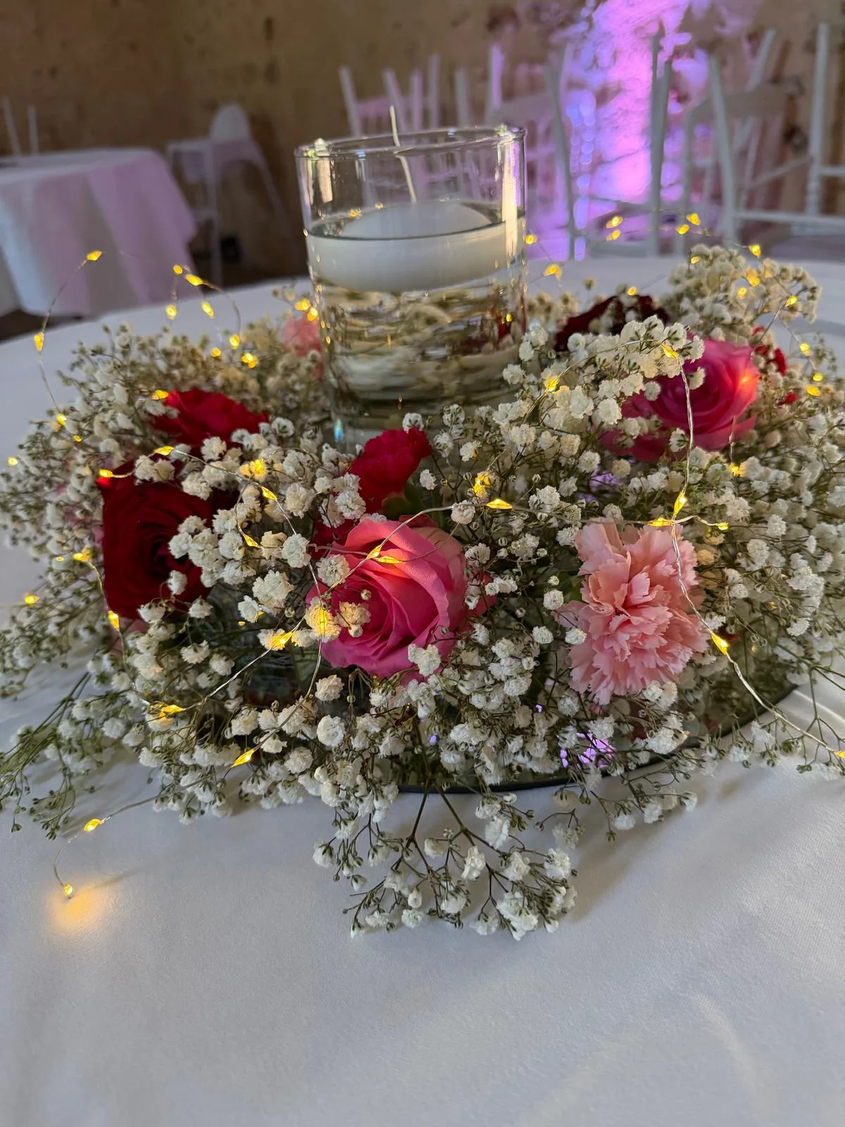 Centre de table aux bougies, roses roses et rouges, gypsophile et guirlande lumineuse – Armony's Déco