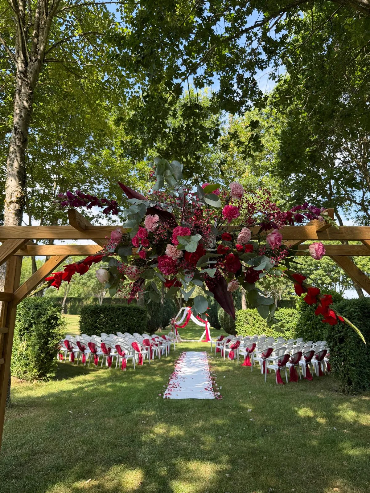 Pergola fleurie de roses rouges et roses au-dessus de l'allée de cérémonie – Armony's Déco