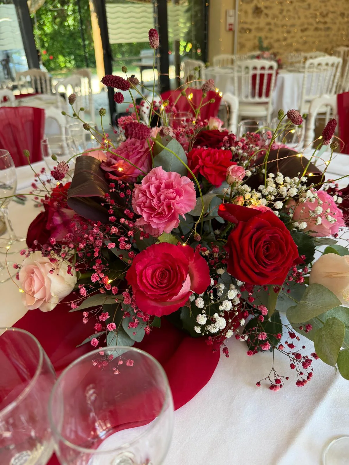 Centre de table en roses rouges, œillets roses et gypsophile, nappe rouge – Armony's Déco