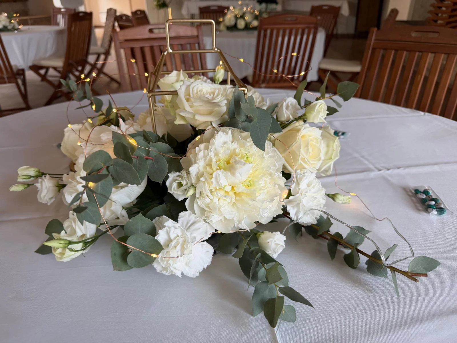 Centre de table en pivoines et roses blanches, eucalyptus et guirlande lumineuse – Armony's Déco