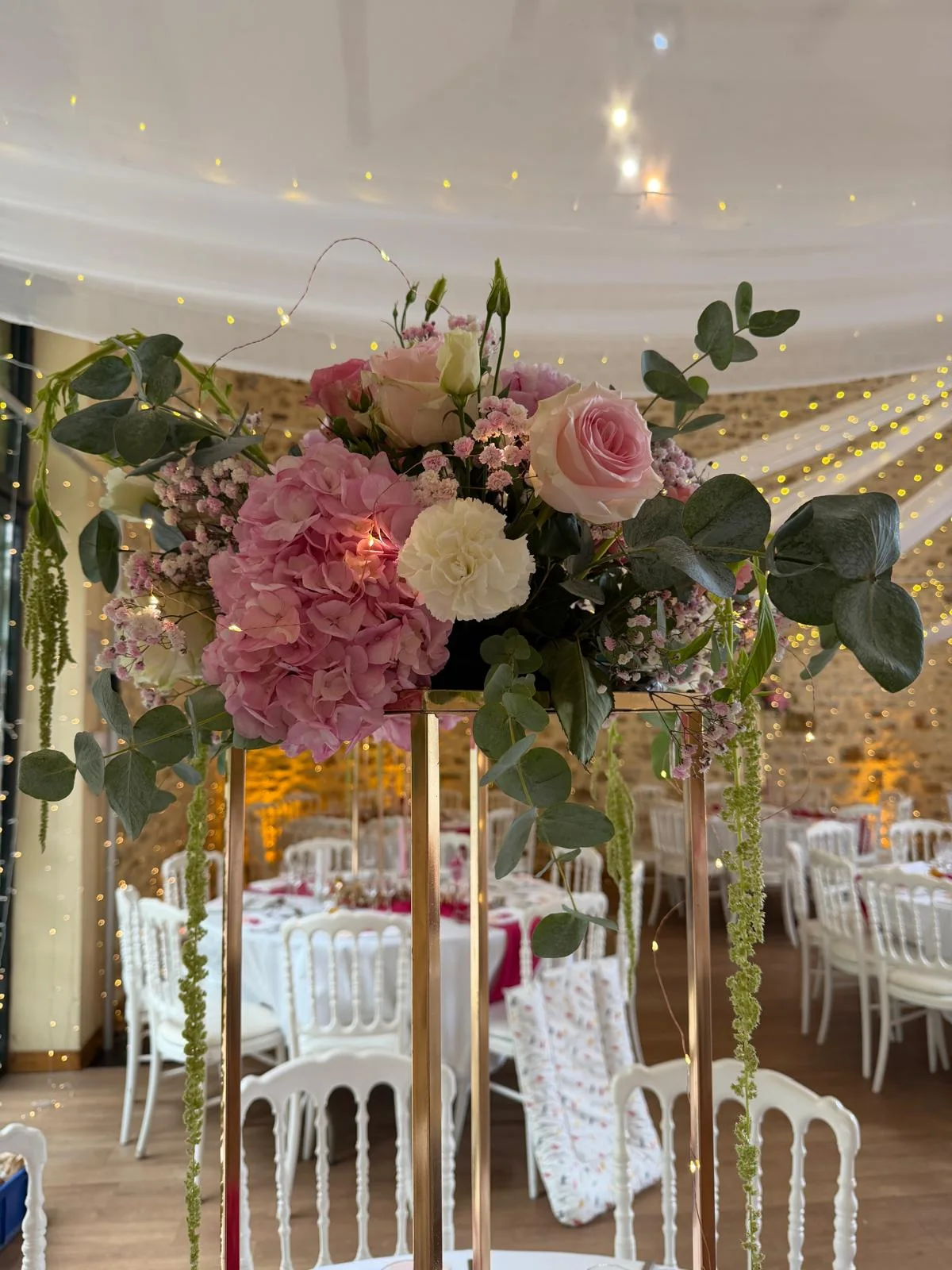 Centre de table haut rose et bordeaux sous un chapiteau lumineux – Armony's Déco