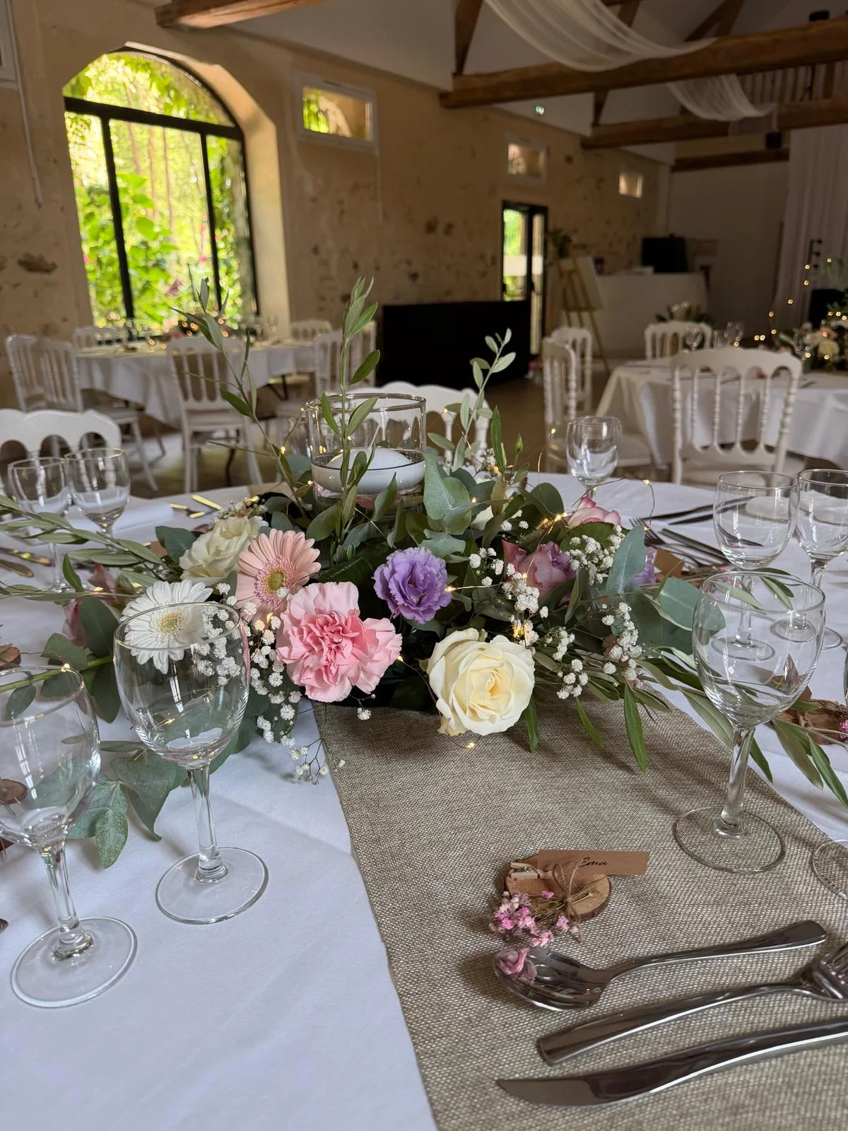 Centre de table pastel : roses, œillets et marguerites sur chemin de table en jute – Armony's Déco
