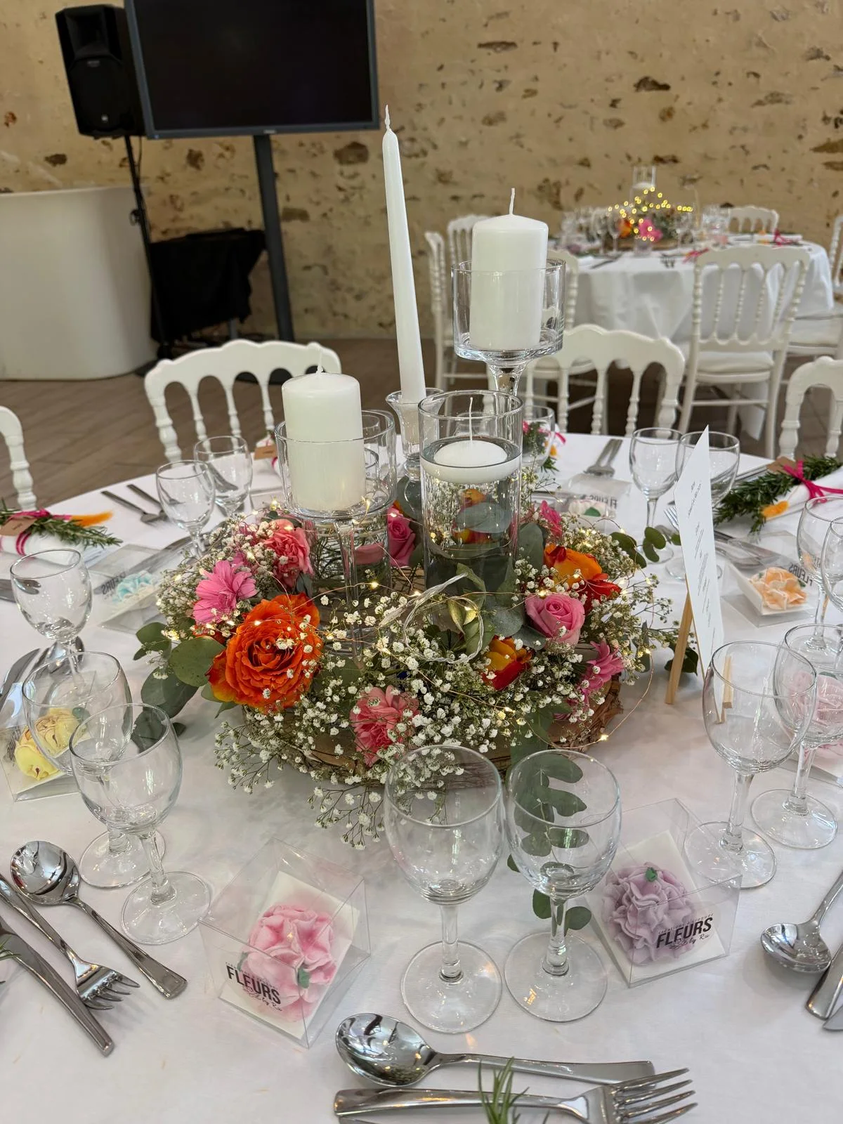 Centre de table rond en roses rose et corail, gypsophile et bougies – Armony's Déco