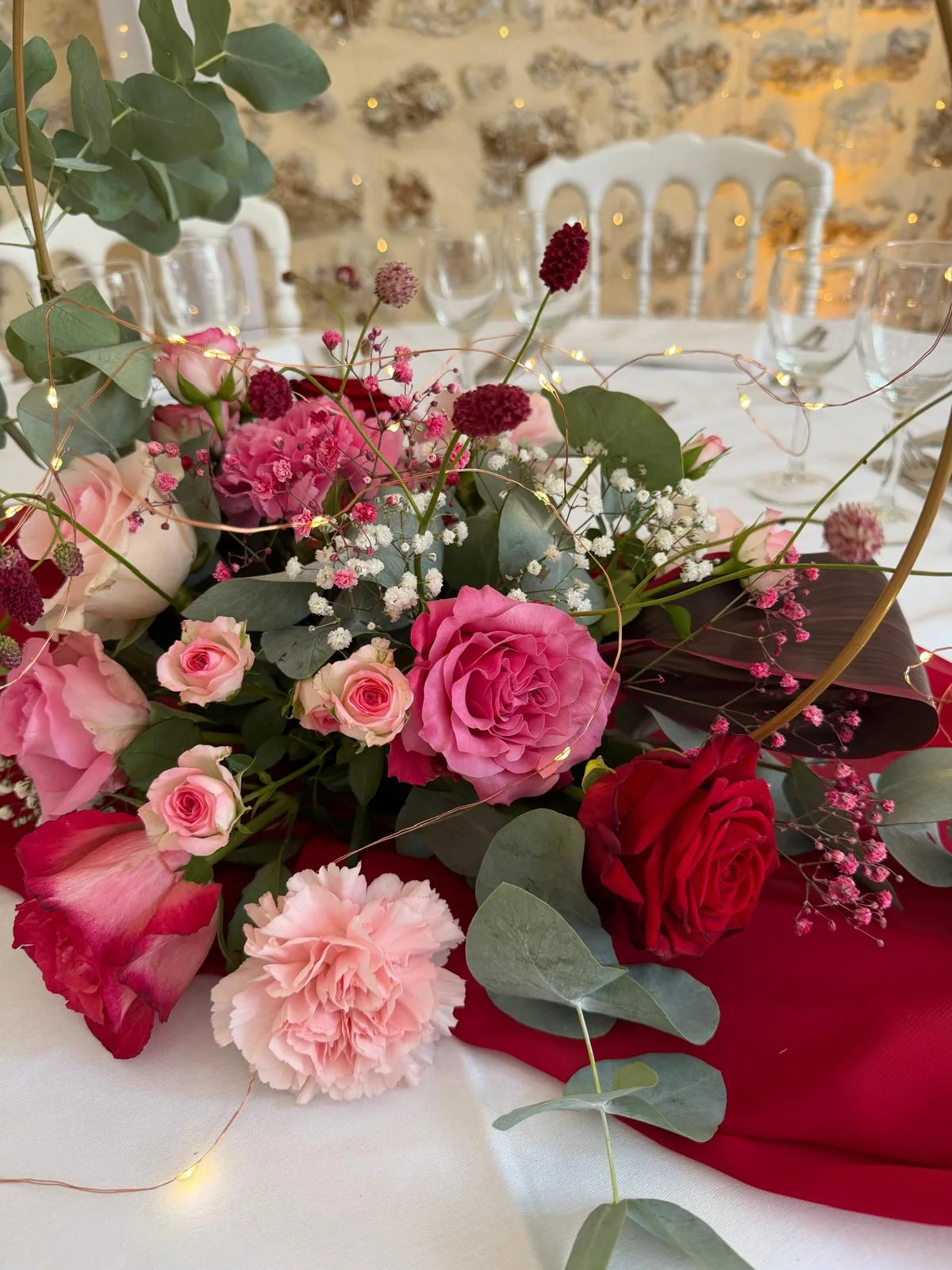 Centre de table rose et rouge : roses, œillets et eucalyptus sur chemin de table rouge – Armony's Déco