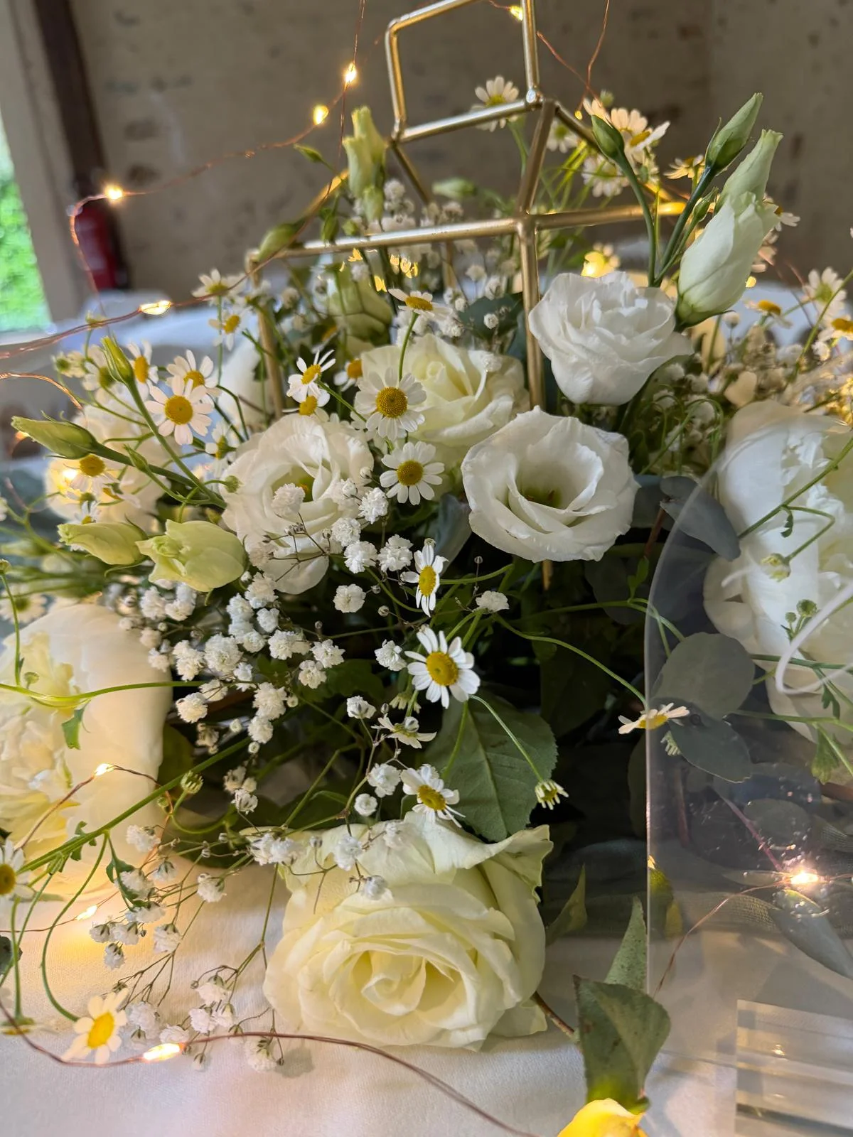 Composition de roses blanches, marguerites et gypsophile sous cerceau doré – Armony's Déco