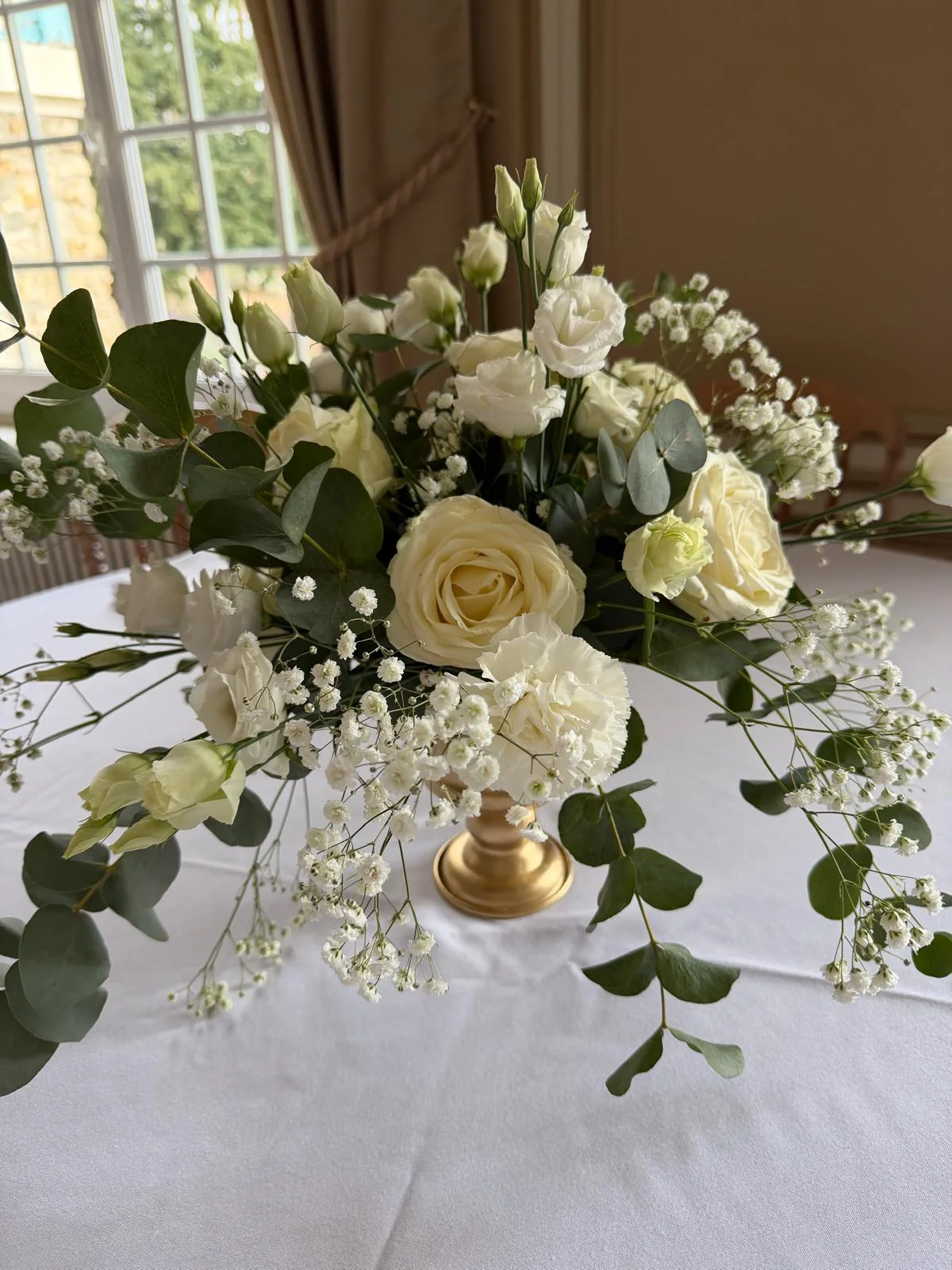 Composition en roses blanches, lisianthus et eucalyptus sur pied doré – Armony's Déco