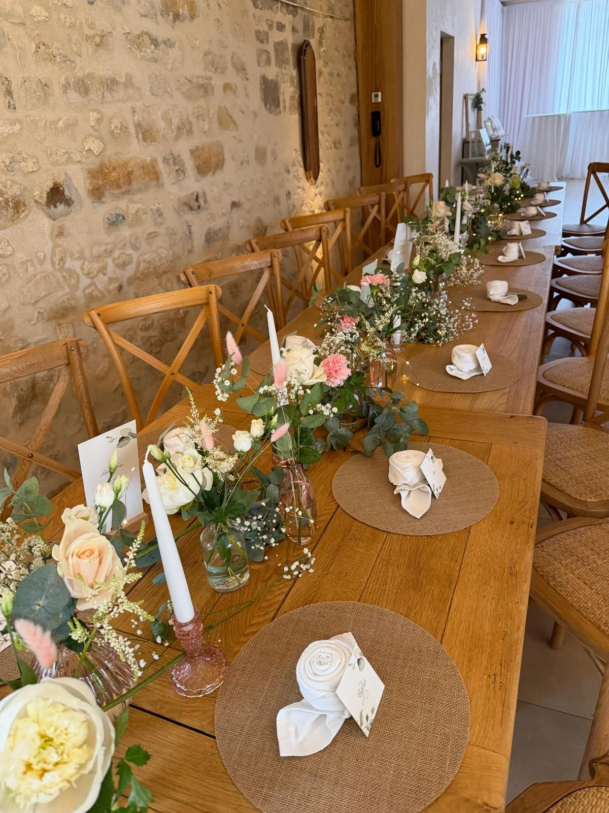 Longue table en bois fleurie de roses blanches et rose pâle, bougies et sets en jute – Armony's Déco