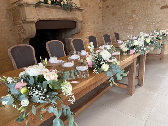 Table d'honneur fleurie dans une salle en pierre – Armony's Déco