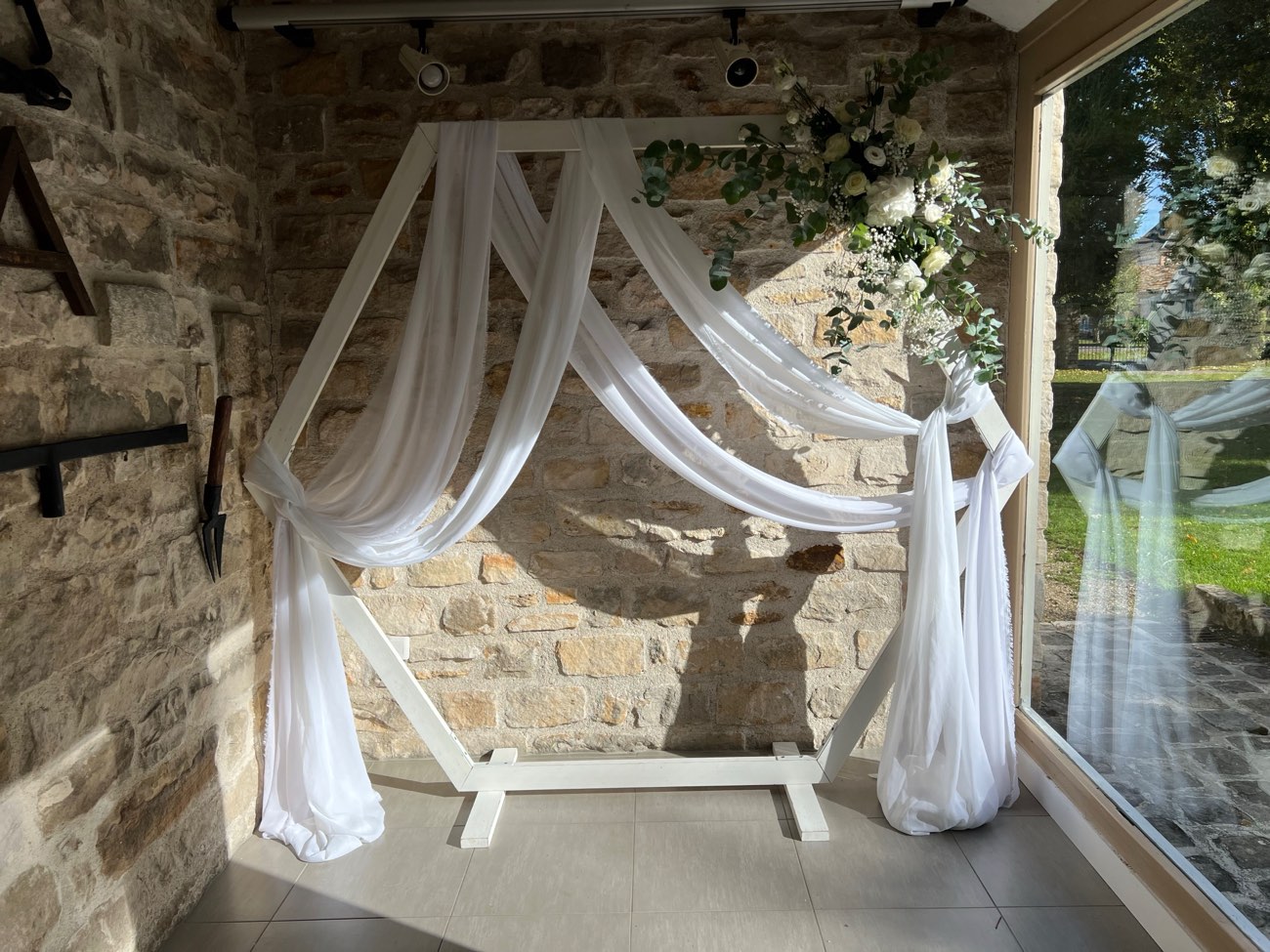 Décoration de mariage : Arche avec voilage et composition florale