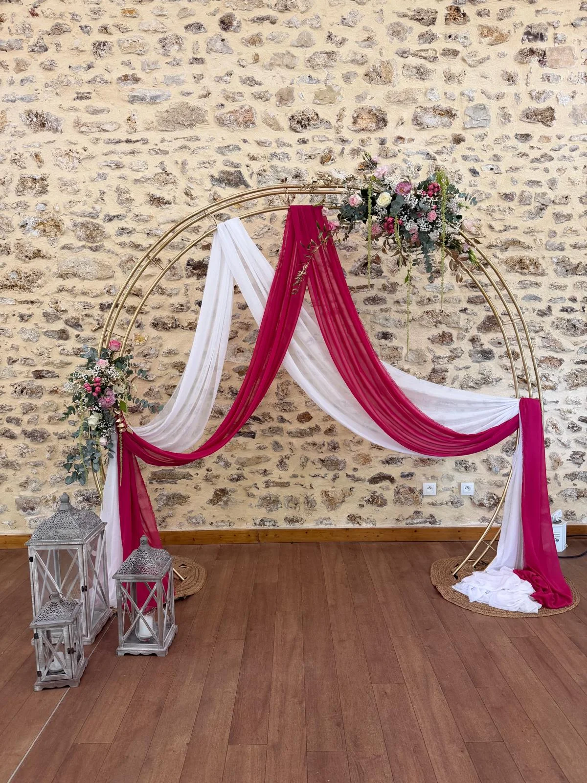 Arche ronde dorée aux voilages blanc et fuchsia, lanternes, mur en pierre – Armony's Déco