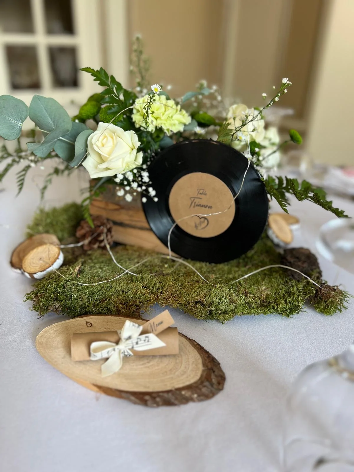 Centre de table thème musique : vinyle, mousse, roses blanches et rondins de bois – Armony's Déco