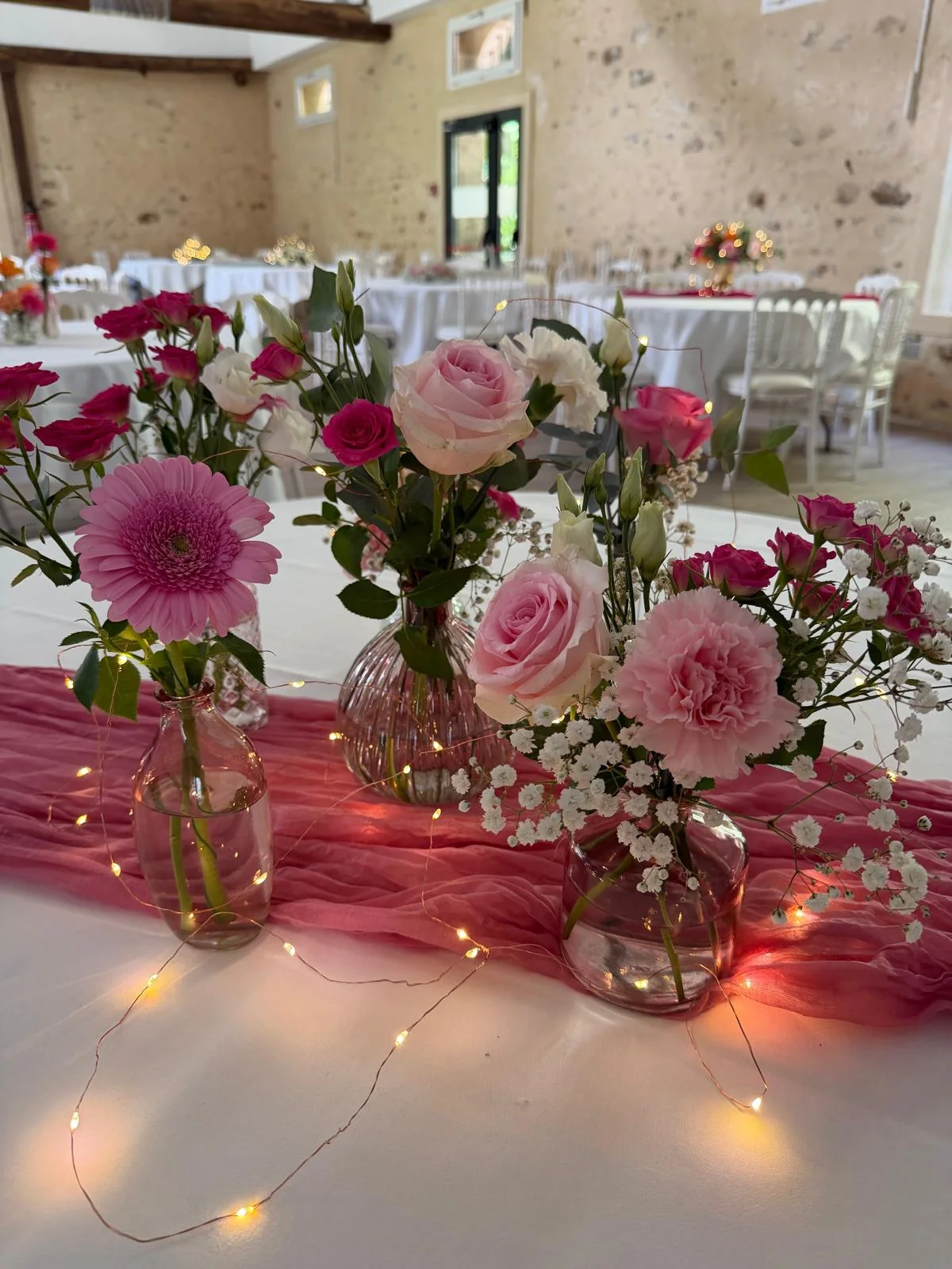 Fioles de roses et dahlias roses sur chemin de table, guirlande lumineuse – Armony's Déco