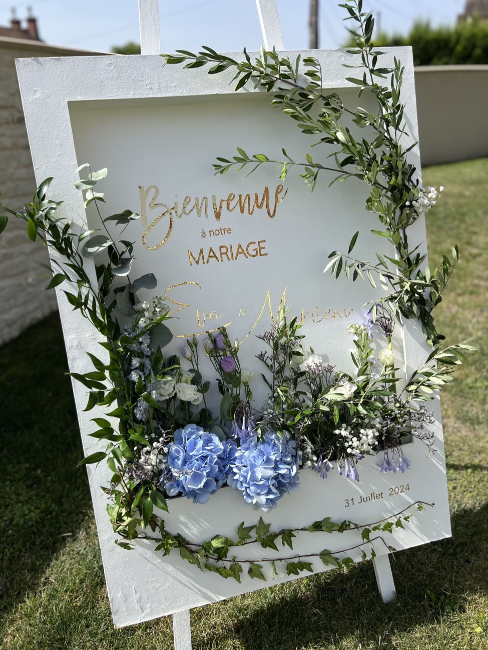 Panneau de bienvenue de mariage fleuri avec eucalyptus et hortensias bleus